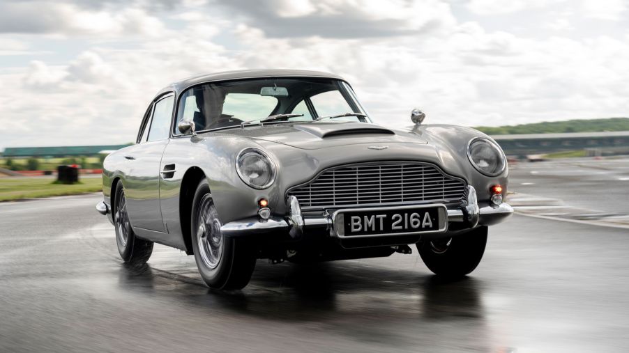 A silver Aston Martin DB5 Goldfinger Continuation on a wet track