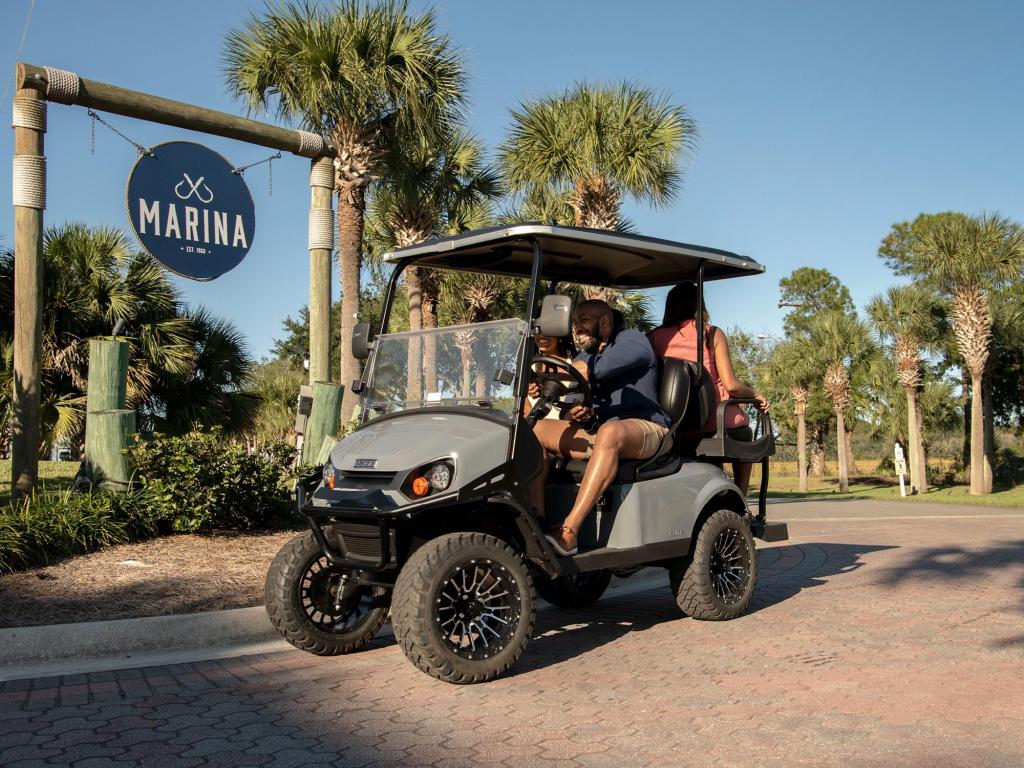A gray golf cart headed to a marina