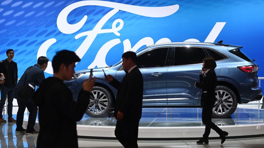 Visitor walk past a Ford Escape Titanium at the Shanghai Auto Show