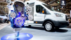 A diesel engine stands in front of a Ford Transit delivery van at Ford's stand at the IAA Commercial Vehicles