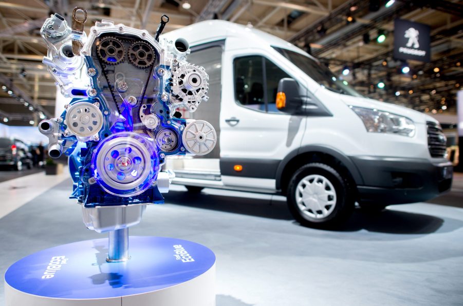A diesel engine stands in front of a Ford Transit delivery van at Ford's stand at the IAA Commercial Vehicles