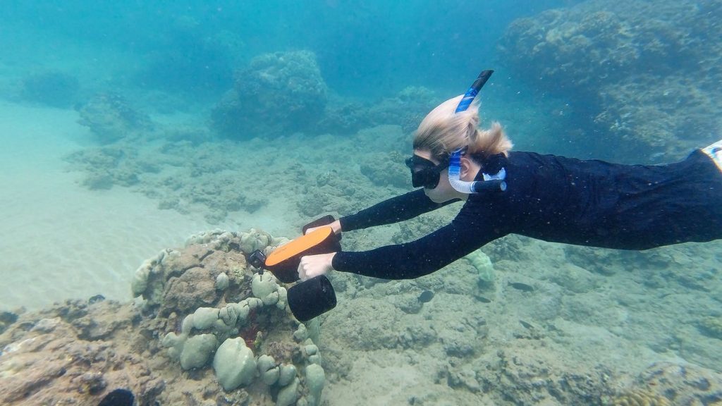 A diver underwater propelled by the Geneinno S2 water scooter.