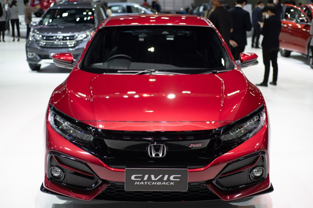 A red Honda Civic Hatchback on display at an auto show