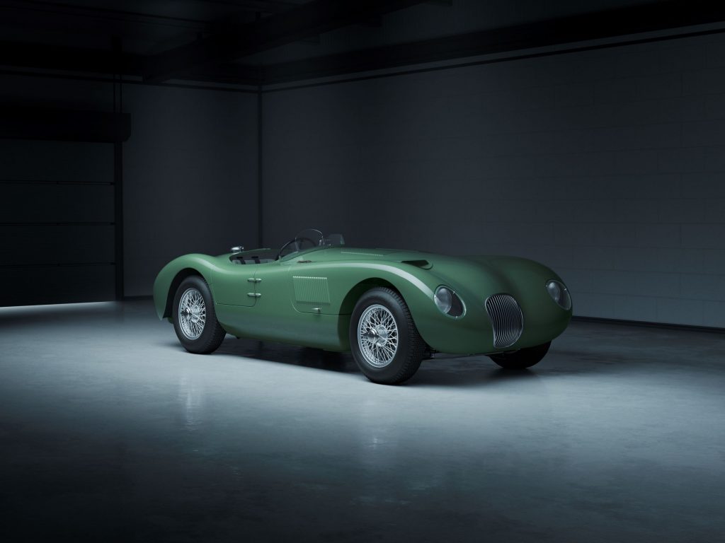 A green Jaguar C-Type Continuation in a hangar