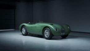 A green Jaguar C-Type Continuation in a hangar