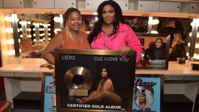 Lizzo and her mom smile proudly next to a plaque