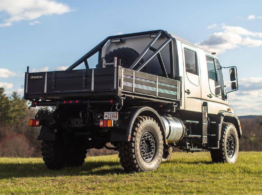 The rear 3/4 view of a modified silver 2004 Mercedes Unimog U500
