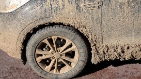 Mud is caked on the side of a car ready for detailing.