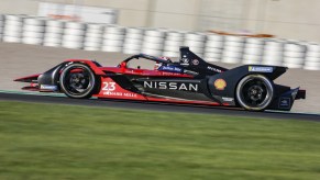 A Nissan racecar speeds down the track