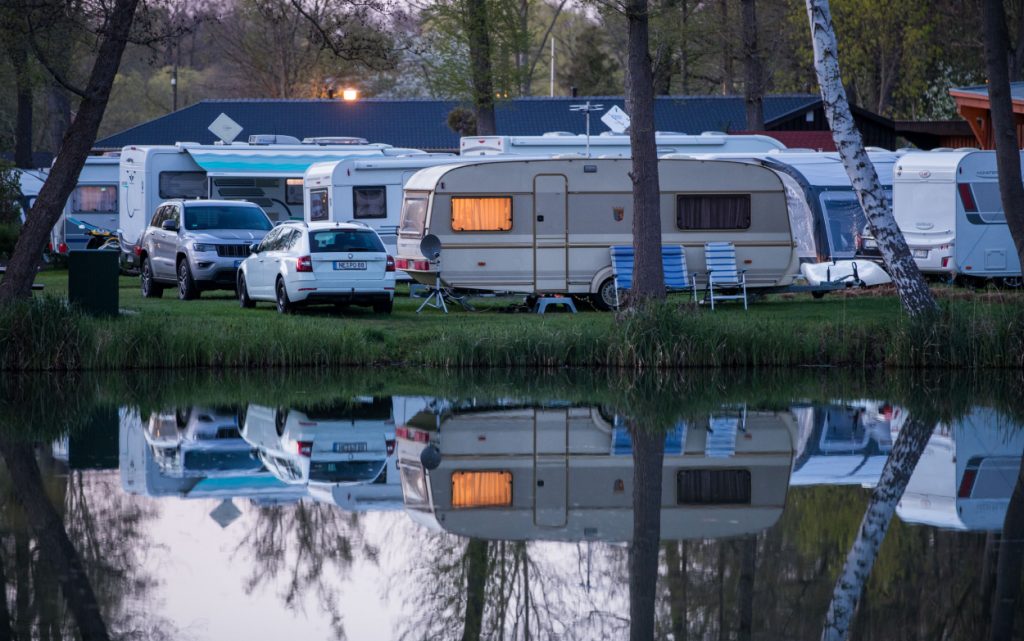 Campers set up in RVs by a lake
