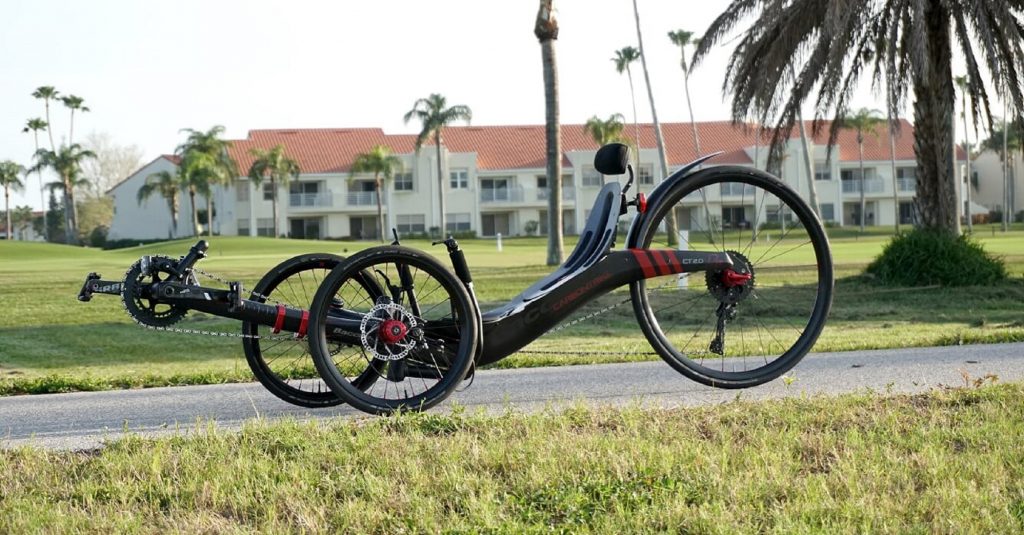 A black-and-red recumbent Bacchetta Carbon Trike 2.0 on a bike trail