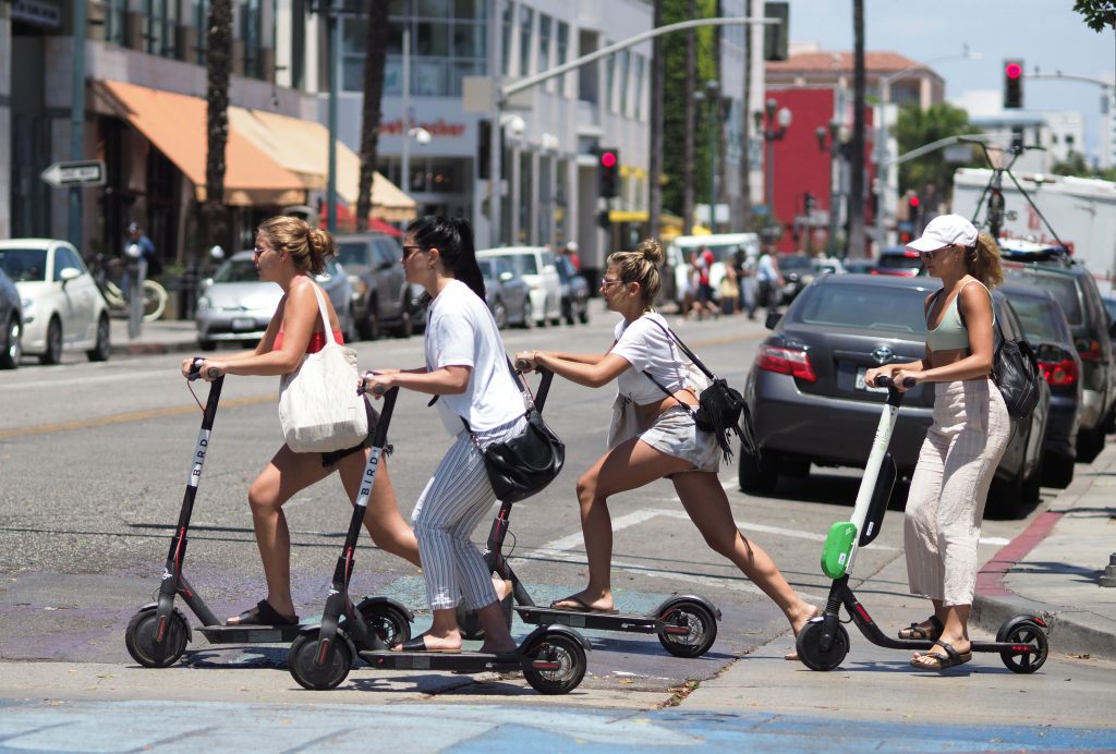 Women ride electric scooters in Santa Monica, California.