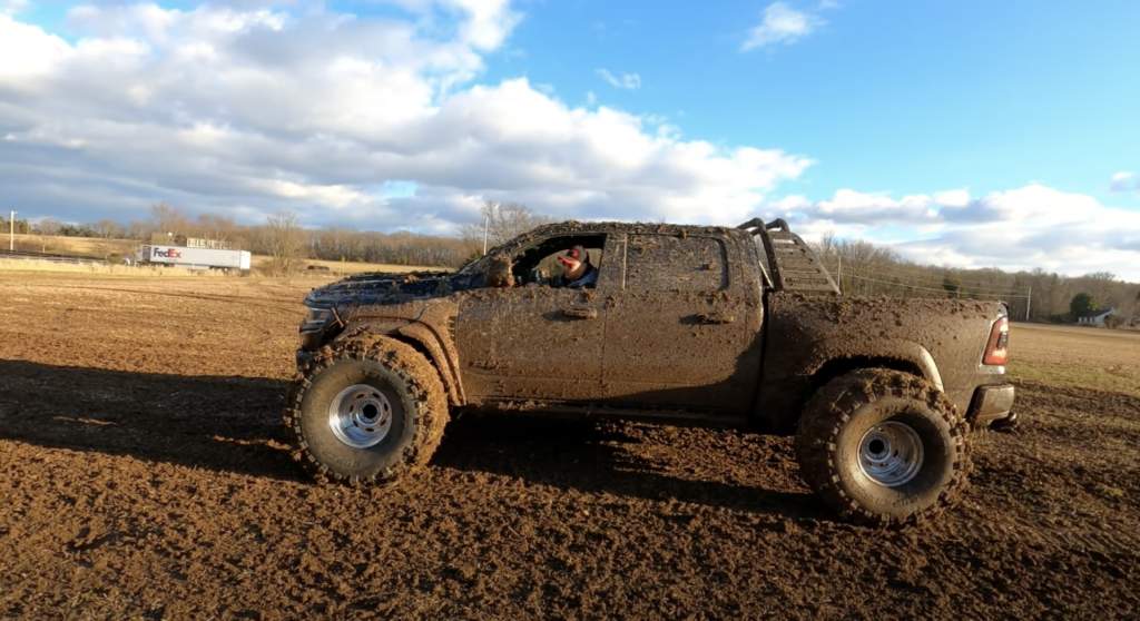 An image of a broken 2021 Ram 1500 TRX on enormous tires off-road.