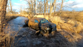 An image of a broken 2021 Ram 1500 TRX on enormous tires off-road.