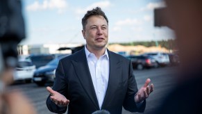 Tesla head Elon Musk, wearing a white dress shirt and sport coat, talks to the press as he arrives to have a look at the construction site of the new Tesla Gigafactory near Berlin on September 3, 2020, near Gruenheide, Germany.