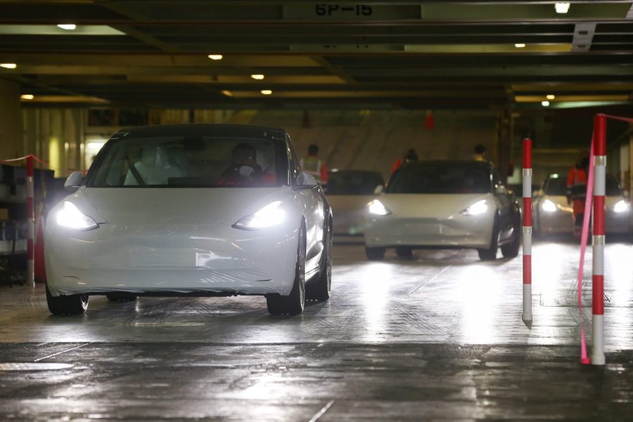 Staff members drive Tesla Model 3 vehicles out of a vessel at Zeebrugge port, Belgium