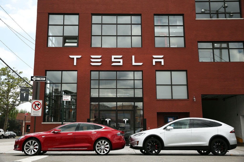 Two Tesla models in front of a building