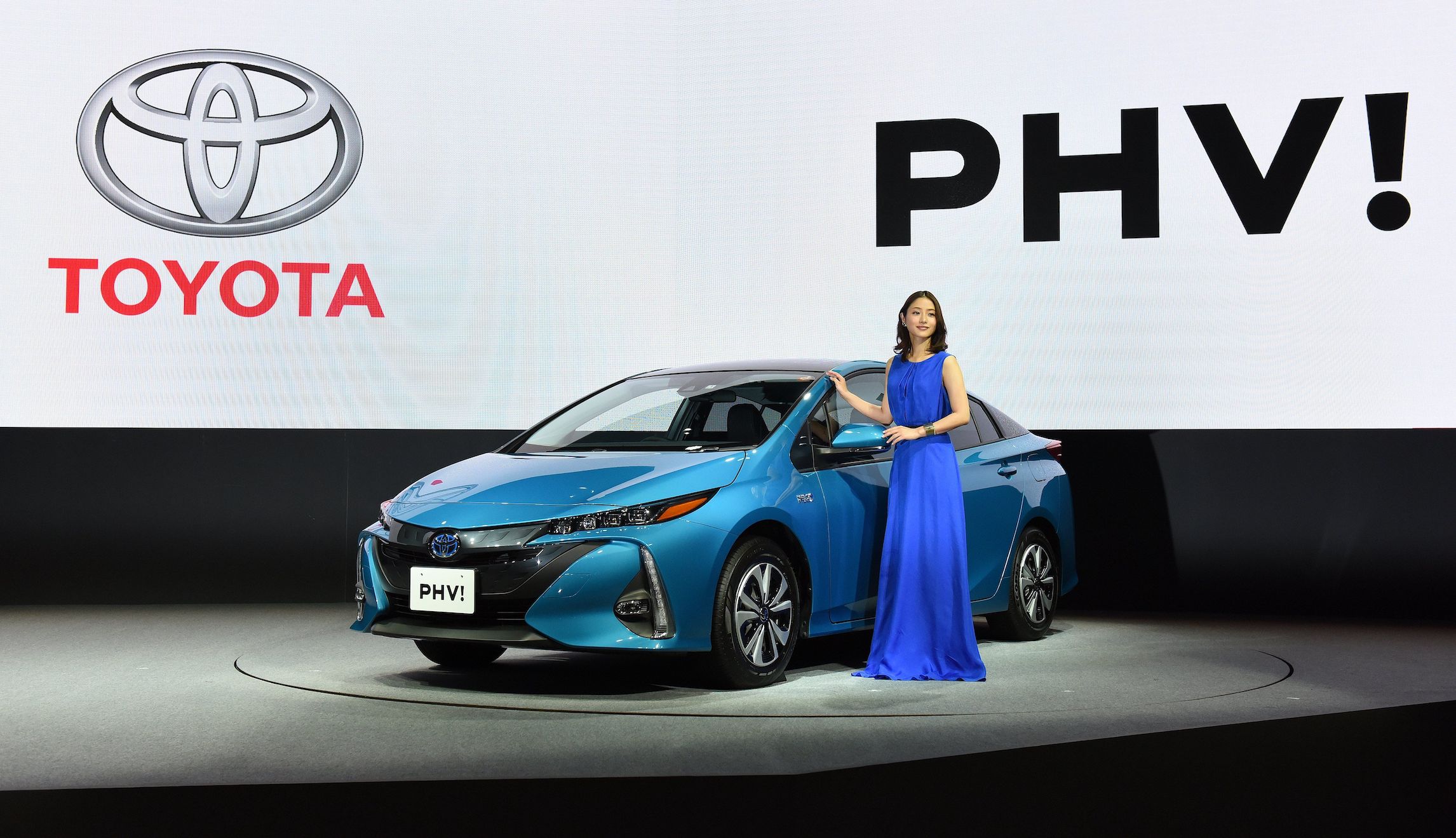 Japanese actress Satomi Ishihara poses beside a redesigned Toyota Motor Prius PHV (plug-in hybrid vehicle) during a press conference in Tokyo