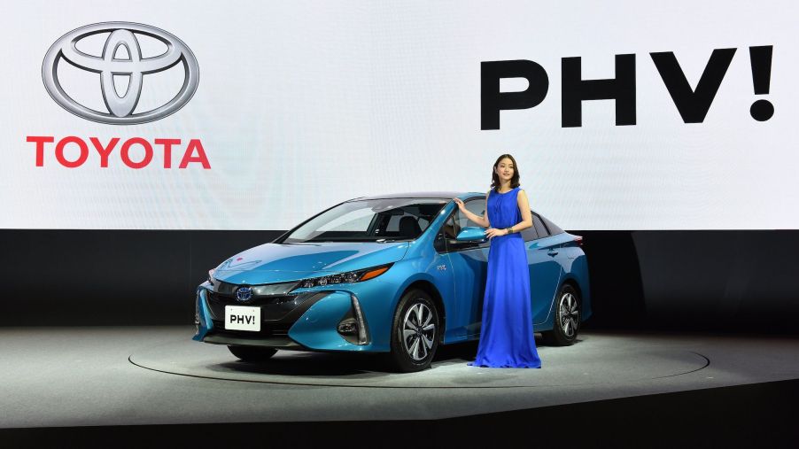Japanese actress Satomi Ishihara poses beside a redesigned Toyota Motor Prius PHV (plug-in hybrid vehicle) during a press conference in Tokyo