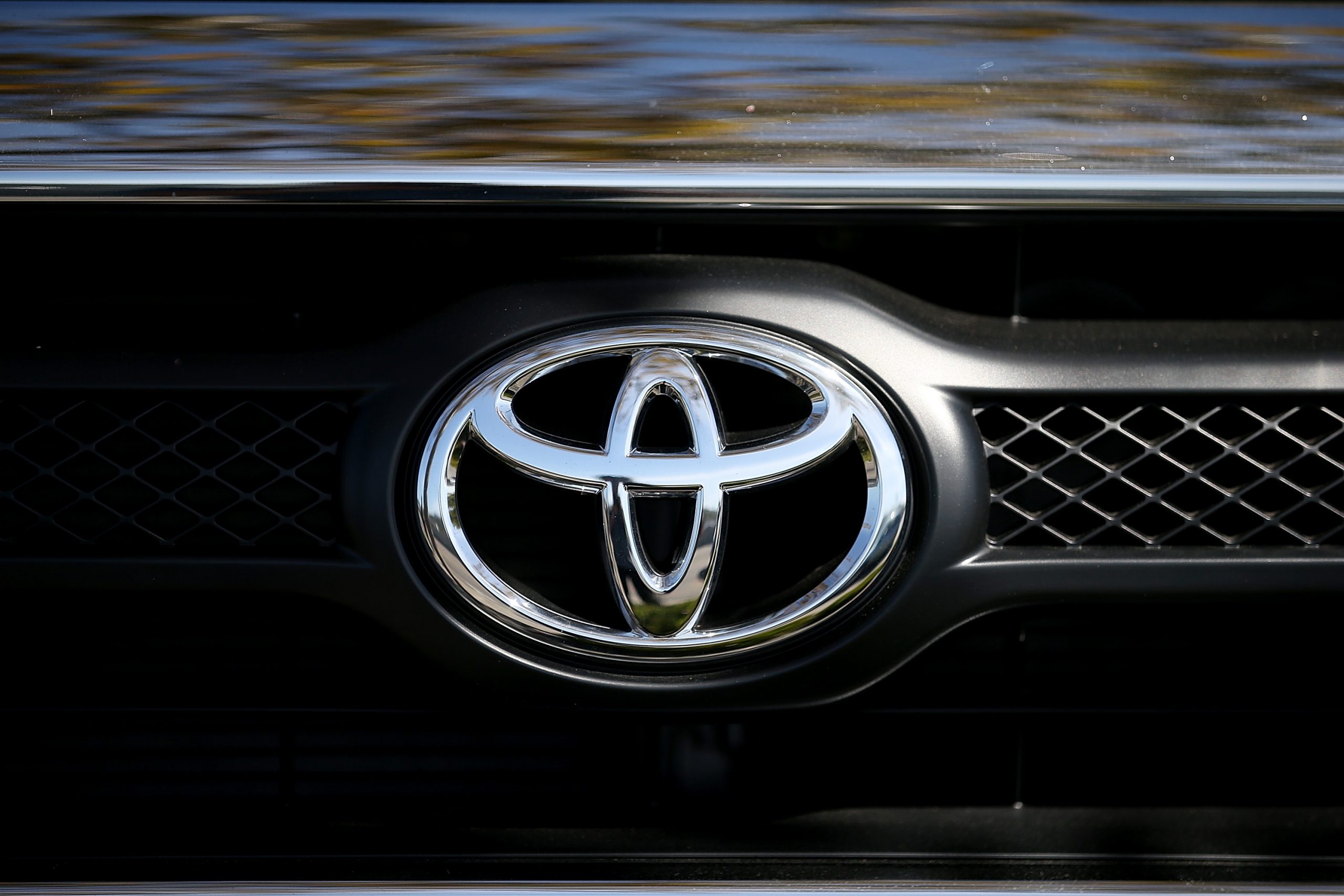 The Toyota logo displayed on the front grille of a truck