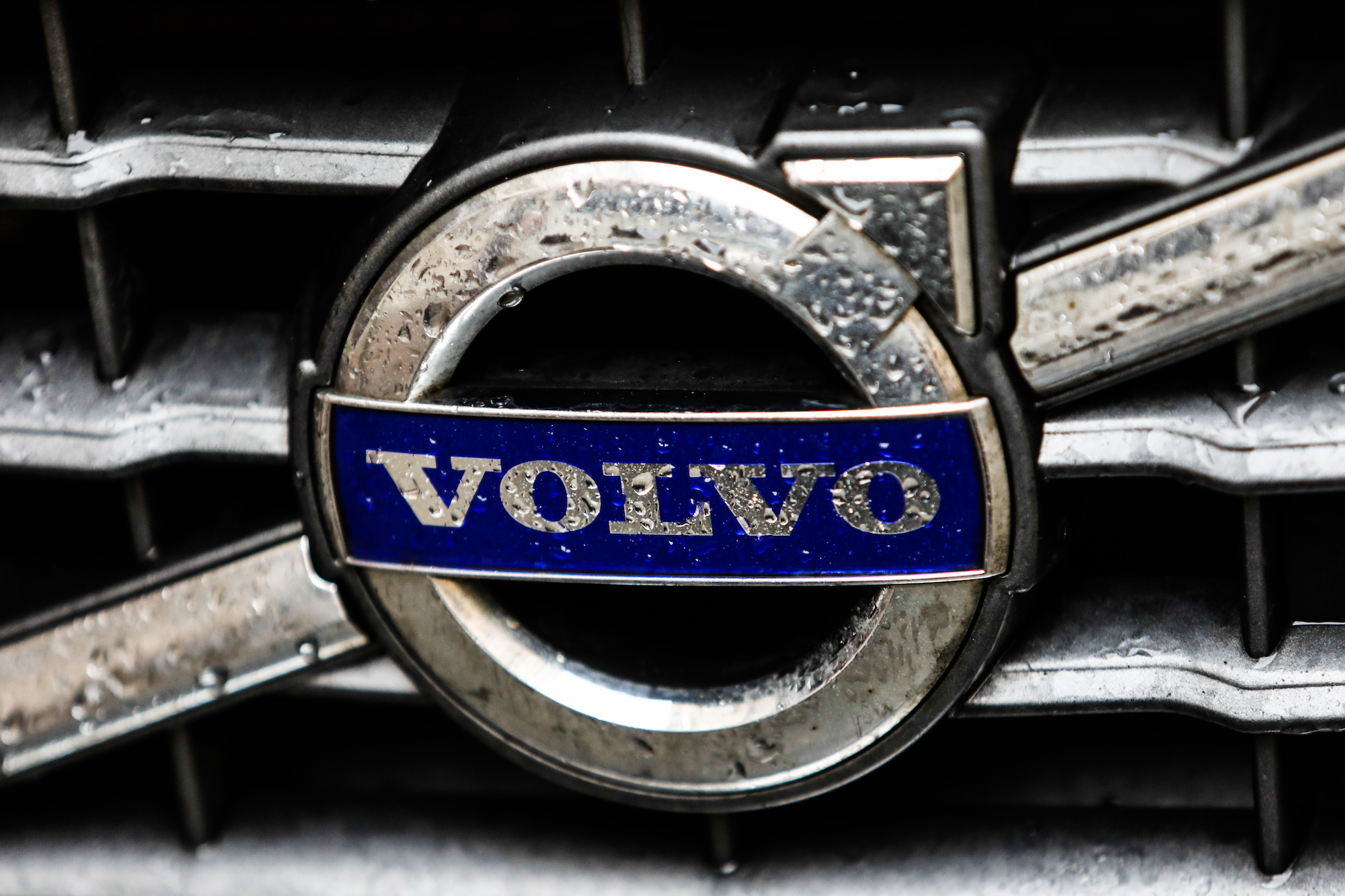Raindrops on a Volvo logo on a car grille