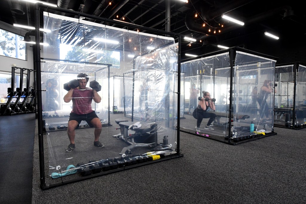 Car safety and Mental or physical health go hand in hand  People exercise at Inspire South Bay Fitness behind plastic in their workout pods