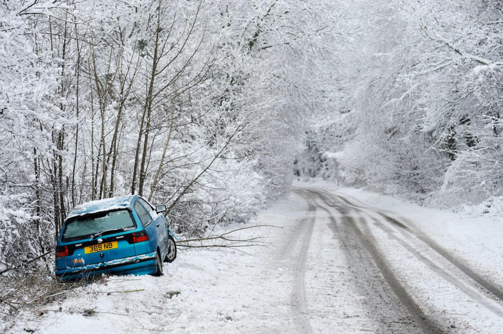Abandoned car by side of road in snowy weather