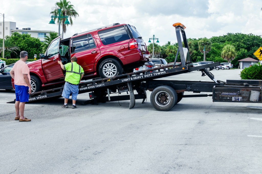 An SUV gets towed away on a tow truck