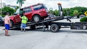 An SUV gets towed away on a tow truck