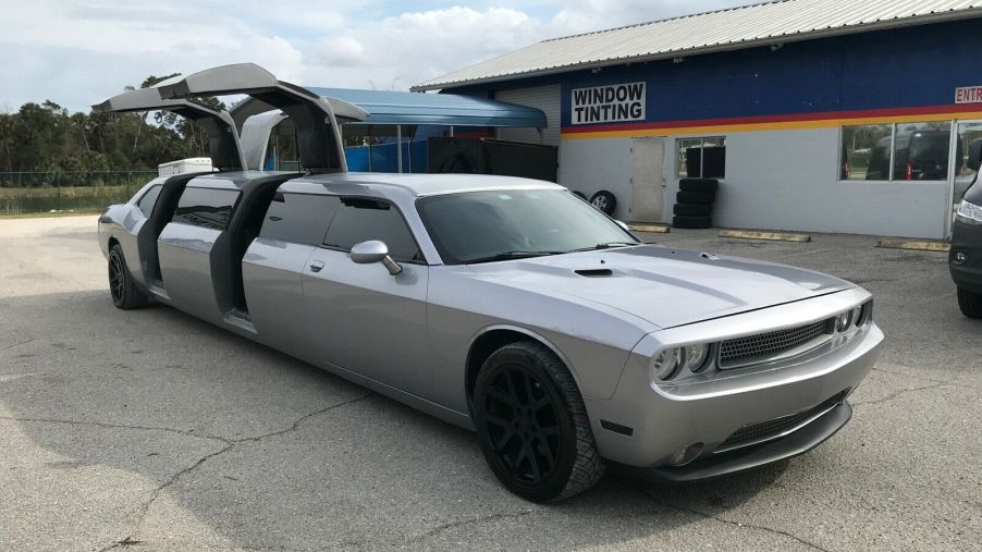 An image of a Dodge Challenger limousine outside with its doors open.