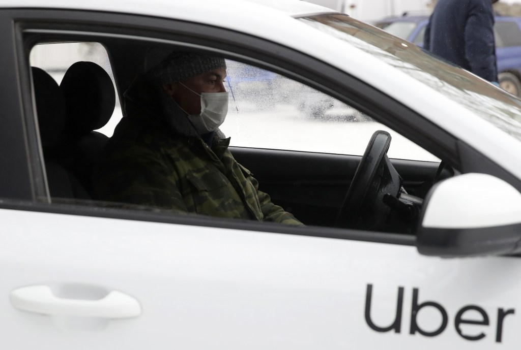 A taxi driver wears a protective mask in a car amid the COVID-19 pandemic