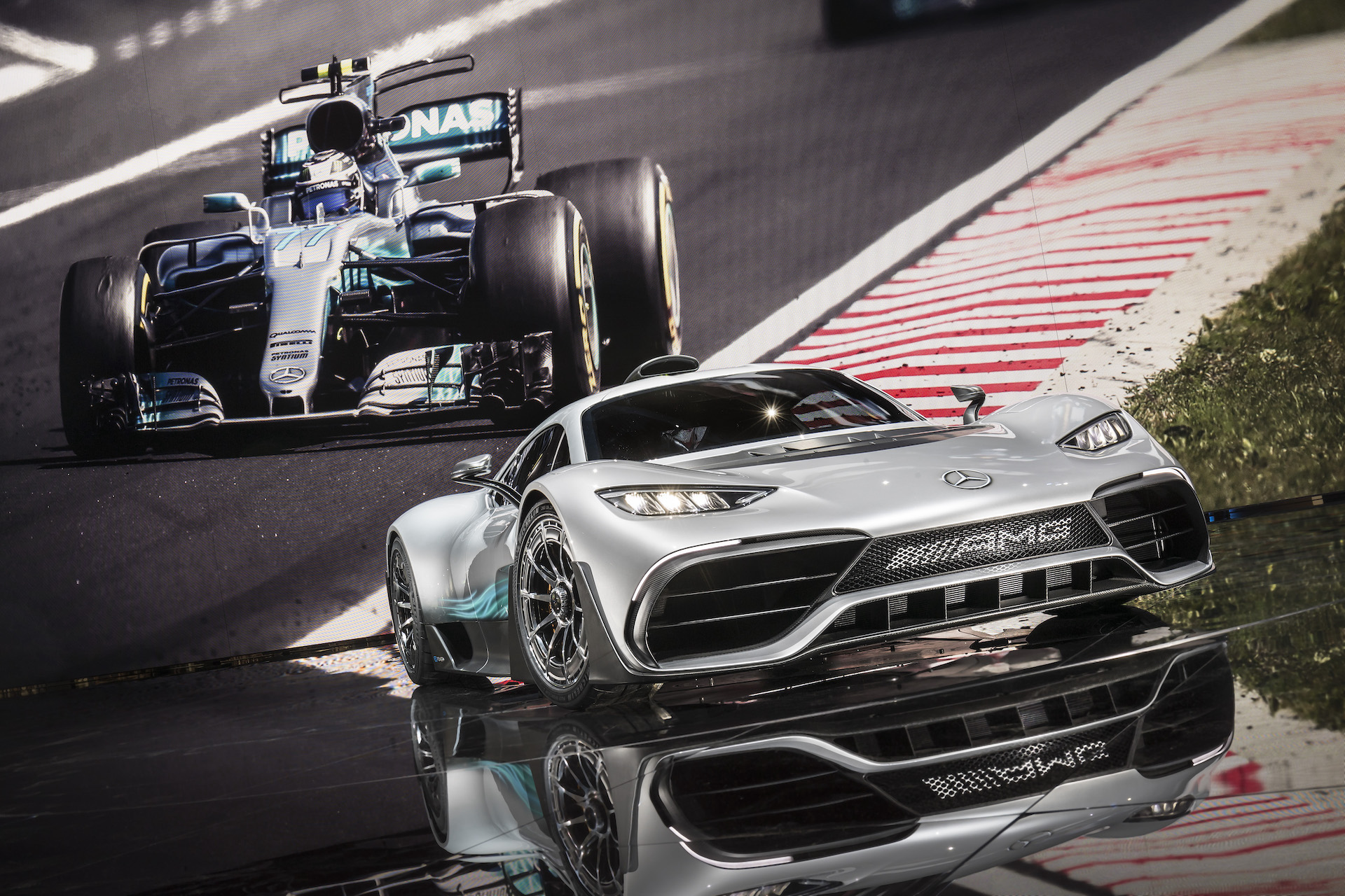 An image of a Mercedes-AMG One on a stage with an image of an F1 car behind it.