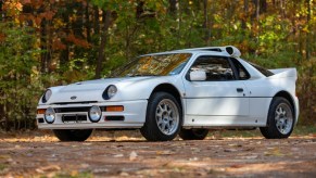 A white 1986 Ford RS200 Evolution in the forest