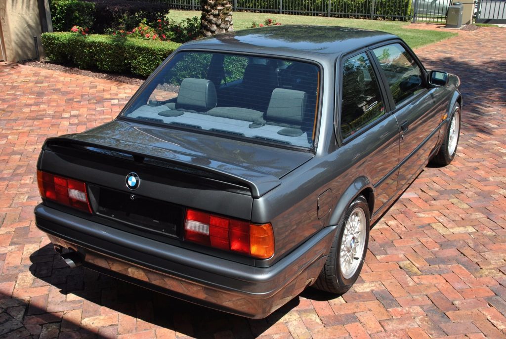 The rear 3/4 view of a gray de-badged 1988 BMW 320is