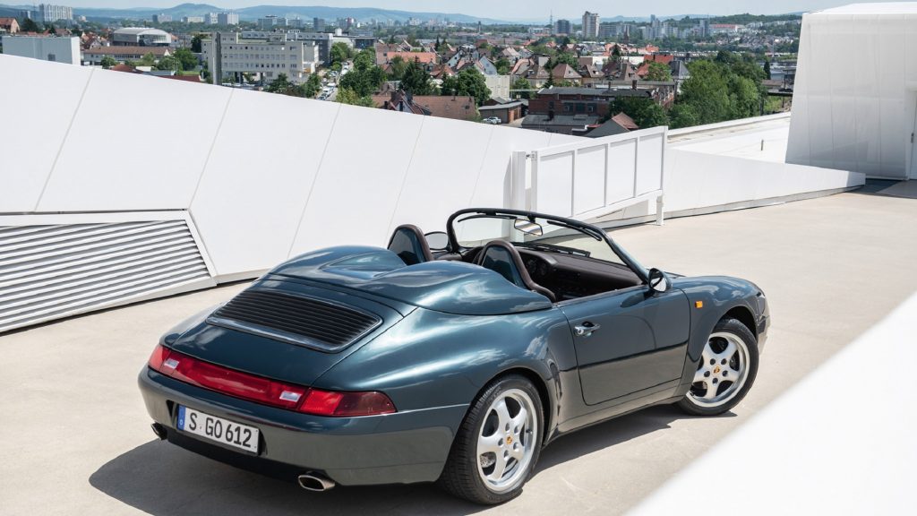 The rear 3/4 view of Ferdinand Porsche's dark-green 1995 993 911 Speedster on top of a roof