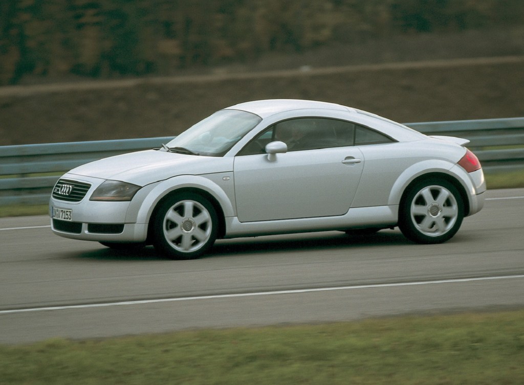 The side view of a silver 1999 Audi TT Coupe on a track