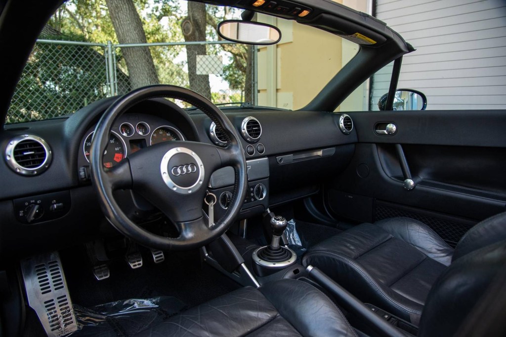 The black-leather front seats and black dashboard of a 2002 Audi TT Roadster
