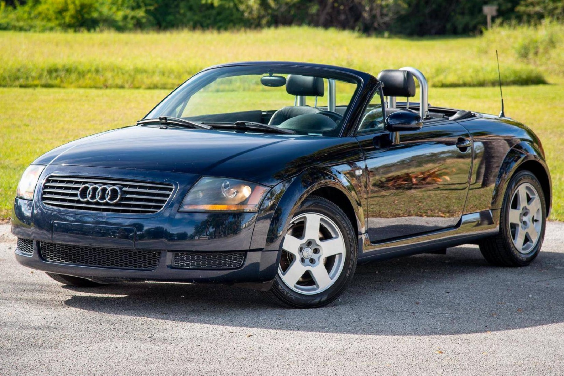 A black 2002 Audi TT Roadster with its roof down