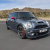 The front 3/4 view of a gray-with-red-mirrors 2006 Mini Cooper S John Cooper Works GP in a desert parking lot