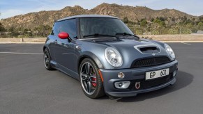 The front 3/4 view of a gray-with-red-mirrors 2006 Mini Cooper S John Cooper Works GP in a desert parking lot