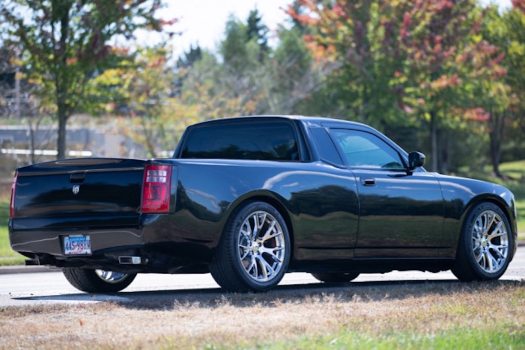 a black 2006 Dodge Charger Ute conversion parked next to a lake