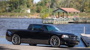 a black 2006 Dodge Charger Ute conversion parked next to a lake