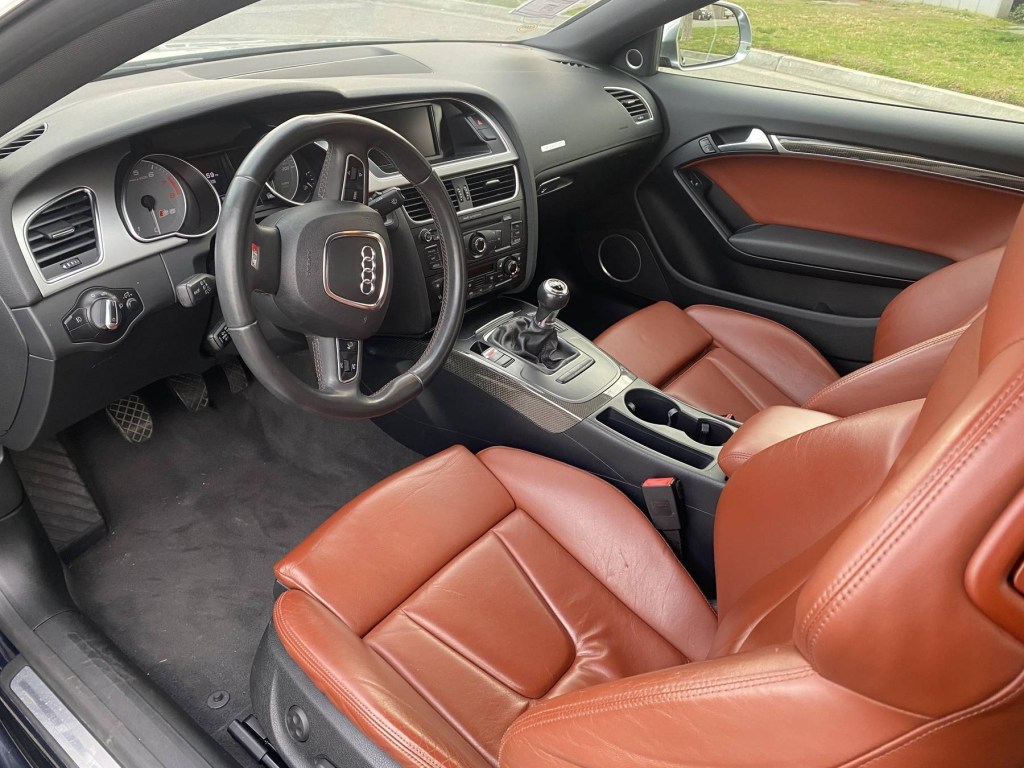 The brown-leather front seats and black dashboard of a 2009 Audi S5 Coupe