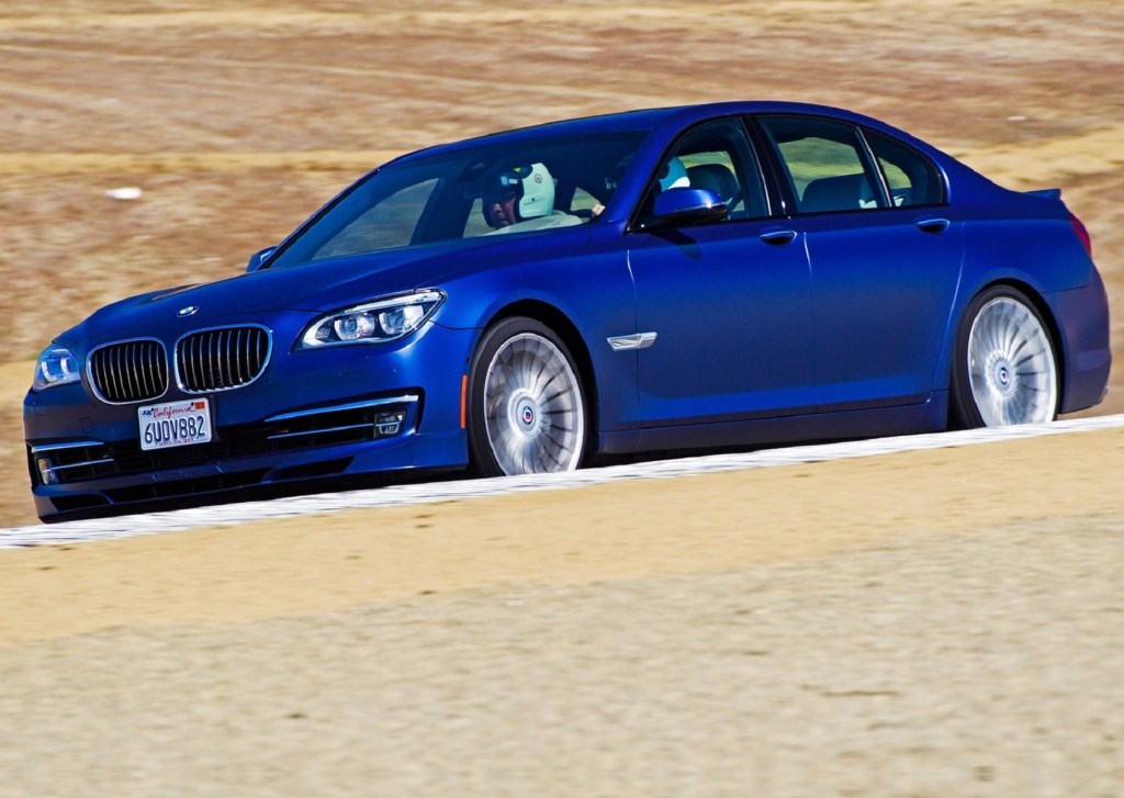 A bright-blue 2013 BMW Alpina B7 drives around a desert racetrack