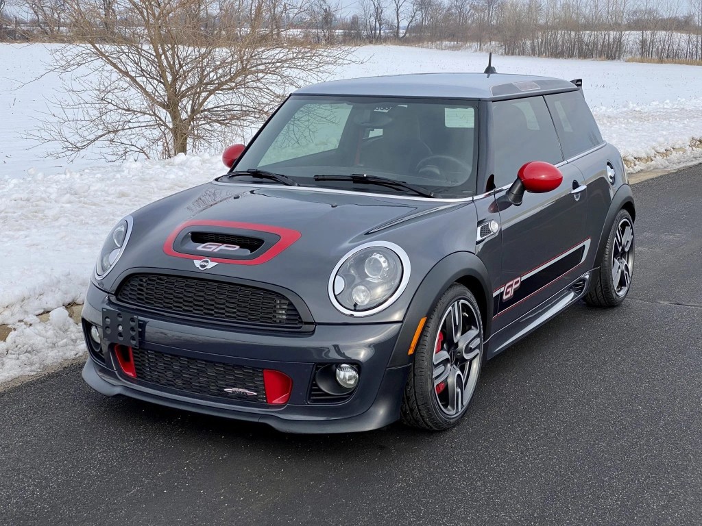 A gray-and-red 2013 Mini Cooper John Cooper Works GP by a snowy field