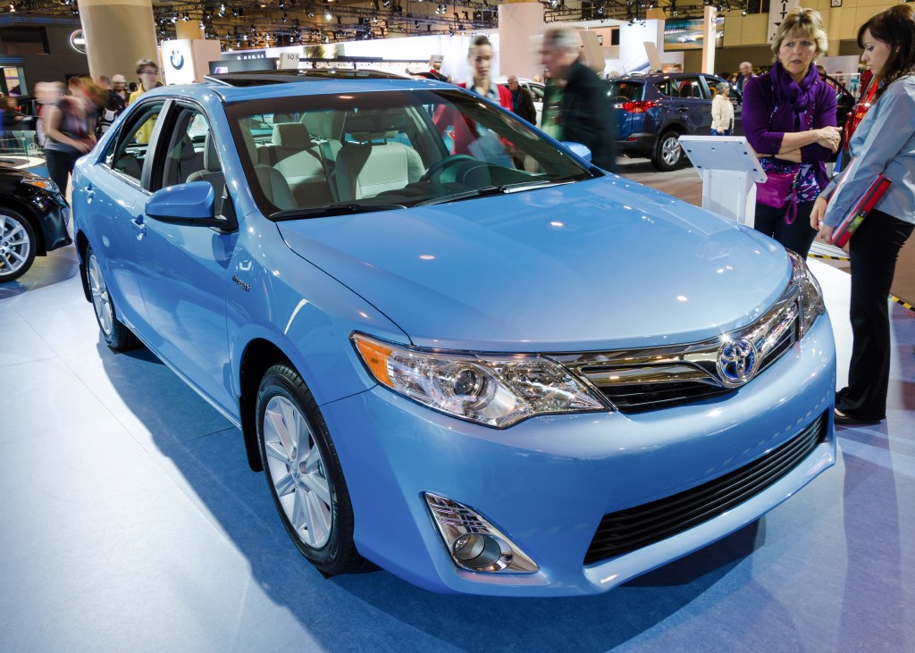 A light blue 2013 Toyota Camry XLE on display at an auto show