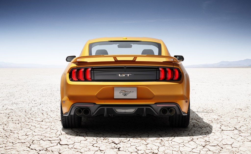 A look at the rear of an orange 2018 Ford Mustang and its iconic taillights