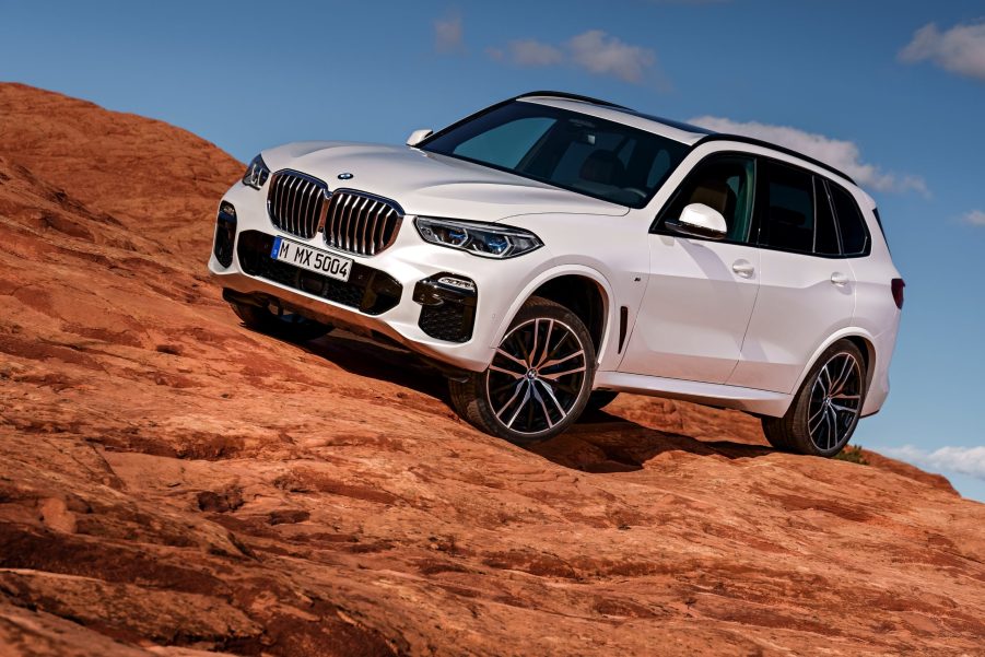 A white BMW X5 parked on rocky terrain
