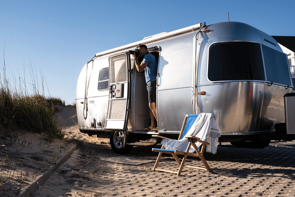 The Airstream Bambi parked at a beach.