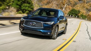 A blue 2020 Infiniti QX50 luxury compact SUV travels on a curvy mountain highway